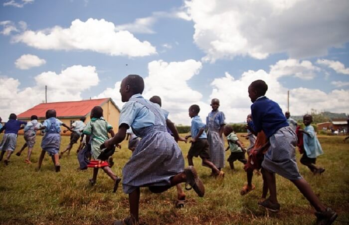 African children cheerfully running in a schoolyard.