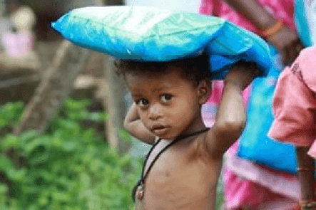 An African child carrying a malaria net over their head.